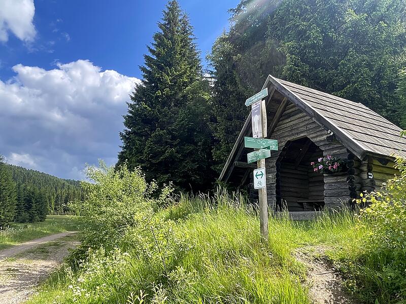 Schutzhütte mit Wegweiser an der Wanderroute